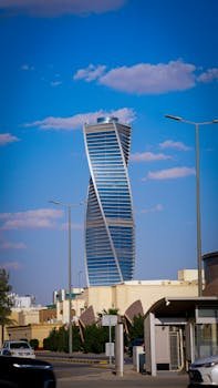 Architectural landmark, the twisted tower in Riyadh against a blue sky.