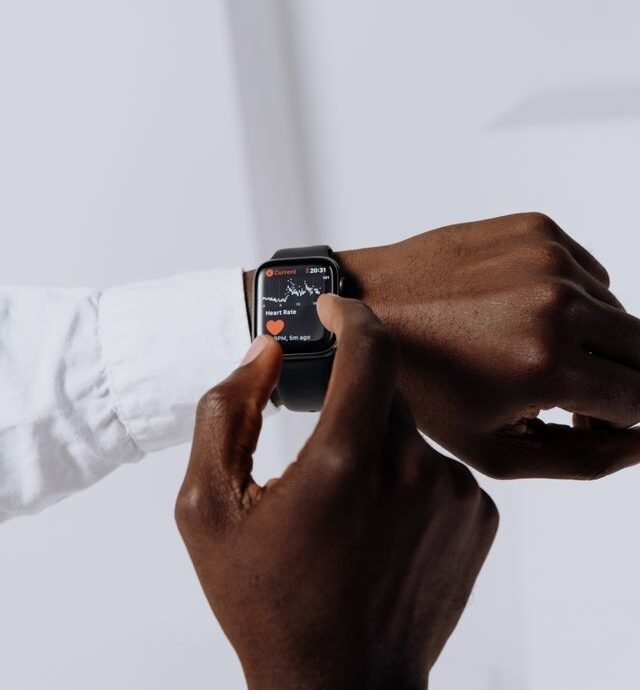 Close-up of a person interacting with a smartwatch for health tracking indoors.